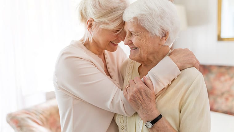 helping a loved one sell their home. Picture of a loving embrace between mother and daughter