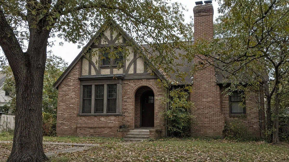 An older brick and half-timber home with a leaf-covered yard in the Dallas–Fort Worth area, sold for cash as-is