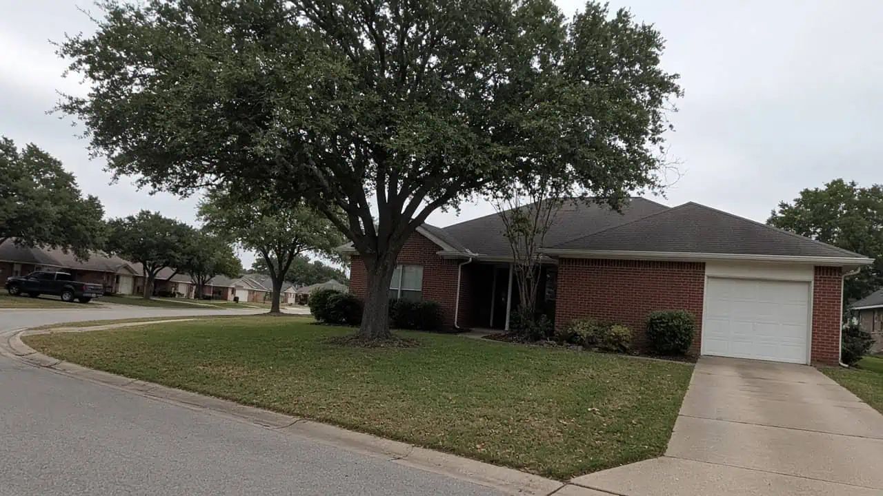 Brick ranch home on a tree-lined street in Plano, TX